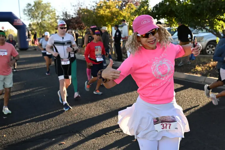 A runner throws her arms wide mid-course