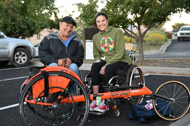 Tricia Downing with her racing wheelchair at sunrise before the Santa Fe International Half Marathon