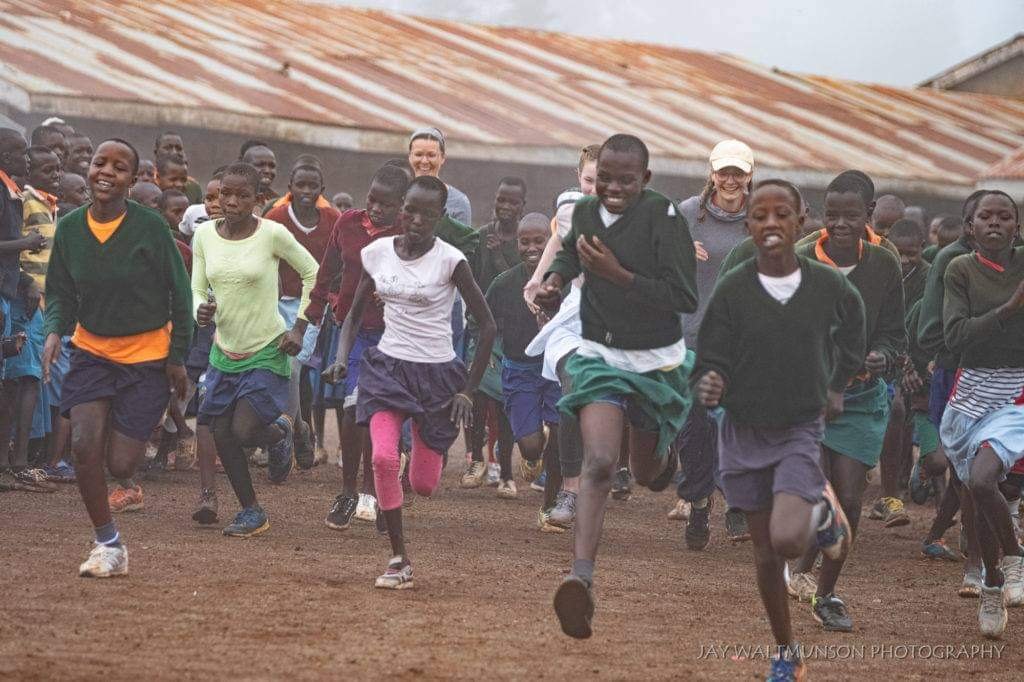 Schoolchildren running together on a dirt ground in Kenya’s Rift Valley