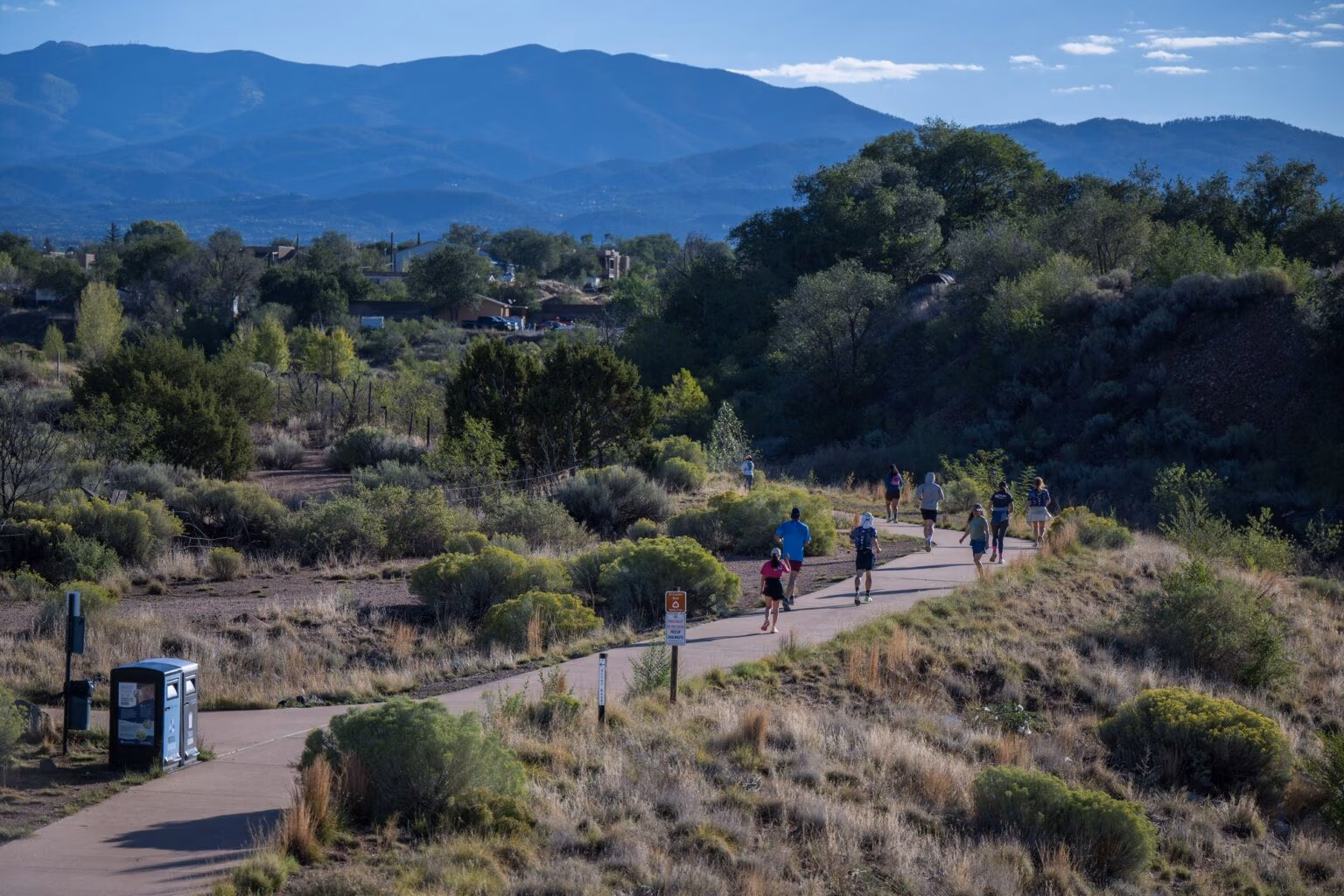 Runners on a trail with mountains on the horizon